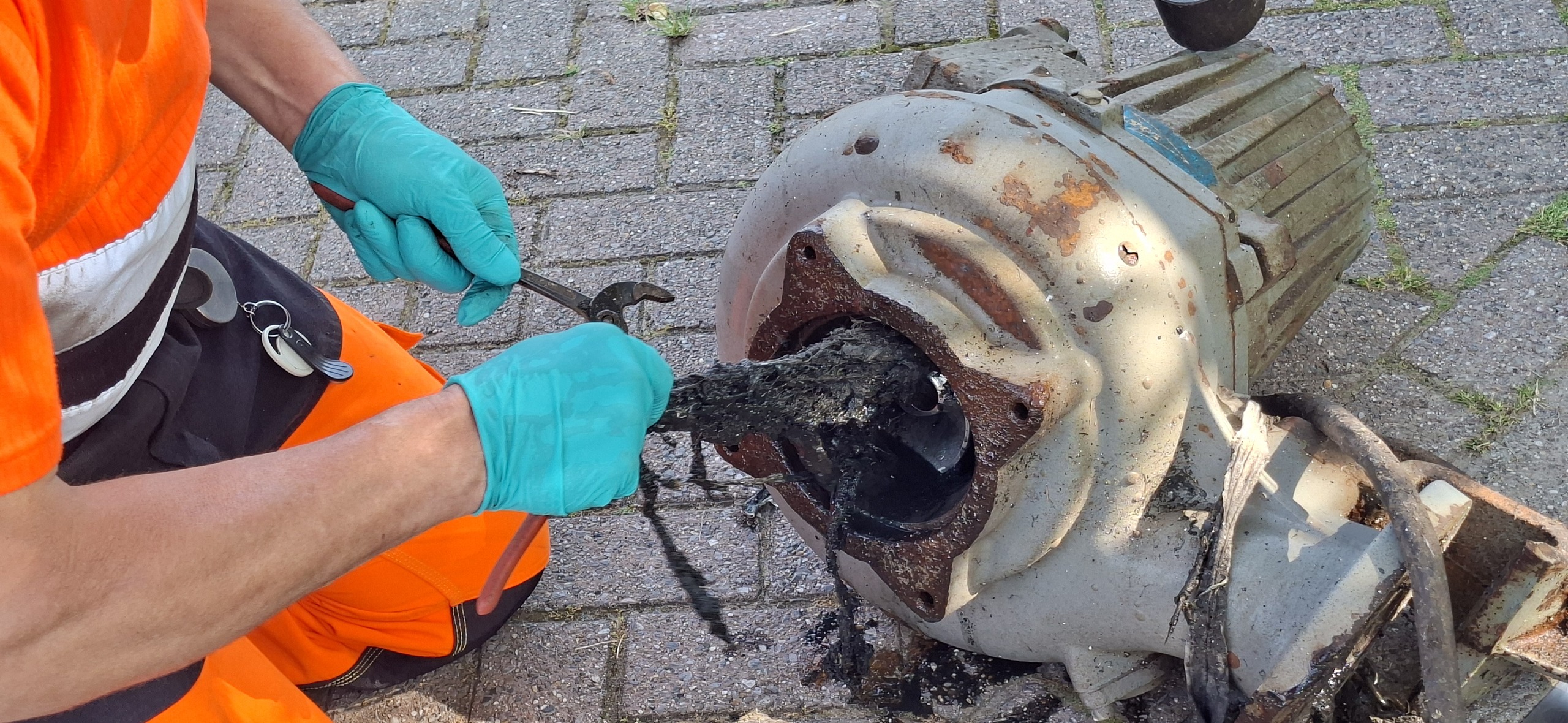 Medewerker van de gemeente Meierijstad maakt een pomp schoon