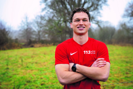 Foto van Stan. Hij draagt een rood t-shirt en staat in een grasveld