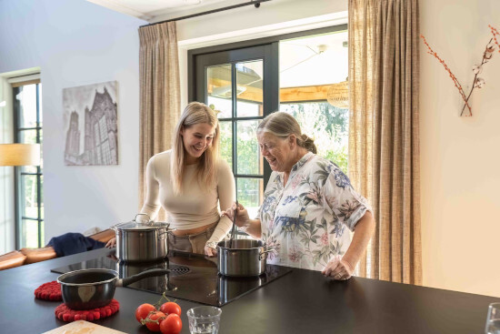 Kamers met aandacht. Op de foto zijn 2 vrouwen (een jong, de andere ouder) samen aan het koken. Foto: Kim van de Wetering
